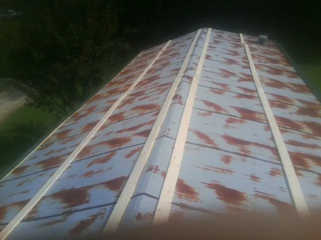 Rusted metal roof panels with new wood purlins before replacement — Storm Damage Roof Repair in Milo by Roofing Brothers