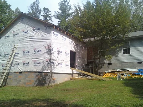 Tyvek wrapped gable on a new room addition beside an existing home in Milo
